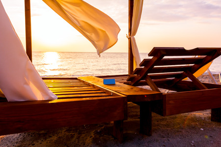 View at early morning Sun, dawn, on public beach with reservation metal plate on luxury and comfortable wooden pergola.の写真素材