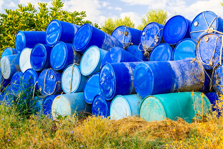 Stockpile of used blue plastic drums for storing water and other liquids.の写真素材