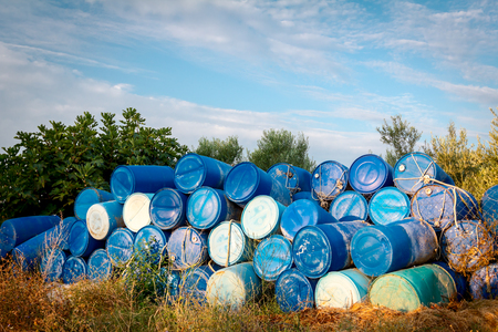 Stockpile of used blue plastic drums for storing water and other liquids.の写真素材