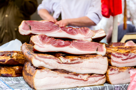 Bunch of cured bacon, meat for sale at outdoor flea market.の写真素材