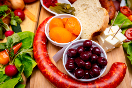 Decorated sausages with fresh vegetables and cherries are exposed on traditional sausage tournament.の写真素材
