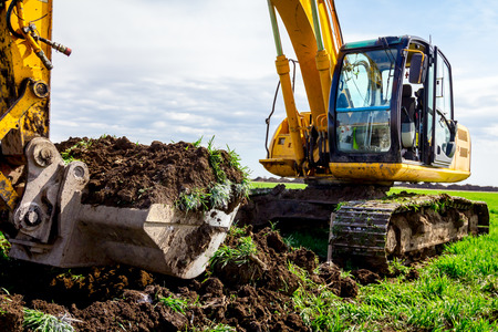 Big excavator is excavating soil at construction site, project in progress.