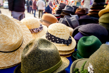 Stacked straw and cloth hats are for sale, available at flea market.の写真素材