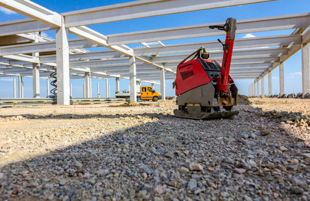 Used plate compactor, vibratory hammer, jumping jack machine, power tool placed in shadow at...