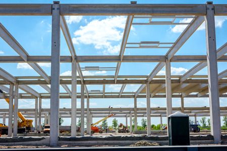 Concrete skeleton of unfinished new edifice and public lavatory for workers is placed at...