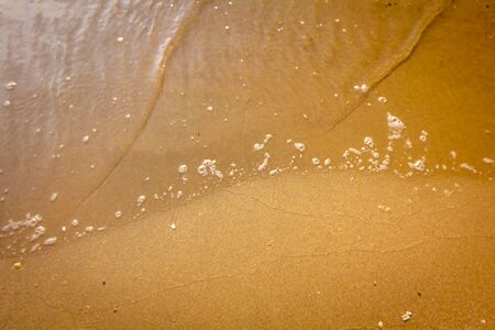 View on the small waves at coastline, sea with foamy waves on early morning.の写真素材