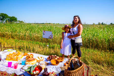 Muzlja, Vojvodina, Serbia, - July 06, 2019; Gypsy mother and daughter are ready for breakfast on picnic at XXXVI traditional wheat harvest.のeditorial素材