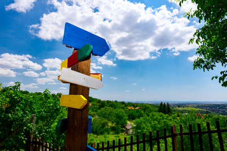 Wooden colorful arrow shape signs, points the way to the different destinations, crossroad signpost.