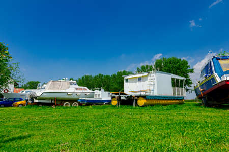 Motor boats on the trailers are dry docked on the grass field.の写真素材