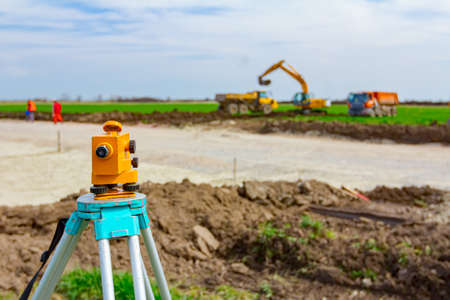 Surveyor instrument is for measuring level on construction site. Surveyors ensure precise measurements before undertaking large construction projects.の写真素材