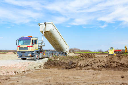 Tipper truck is lifted his trailer to unload cargo, fraction, small crushed stone.