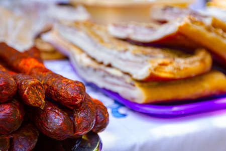 Bunch of cured smoked sausages and bacons, meat is for sale at outdoor flea market.の写真素材