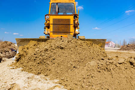 Earthmover with caterpillar is moving earth outdoors.