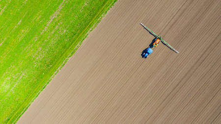 Above top view, overhead view on tractor until spraying big endless farmland dragging mounted wide...