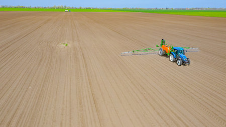 Above view, overhead view on tractor until spraying big endless farmland dragging mounted wide...