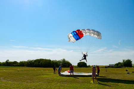 Parachutist it slows down for accurate landing on target place. Skydiving, gliding, parachute jump.