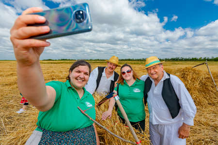 Muzlja, Vojvodina, Serbia, - July 03, 2021; XXXVIII Traditionally wheat harvest. Woman takes selfie...