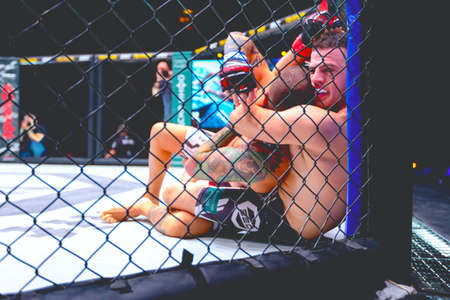 Zrenjanin, Vojvodina, Serbia October 16, 2021: MMA XXXVI SBC Tournament Two strong muscular professional MMA fighters fighting, they are in clinch, wrestling in parterre on octagon floor.のeditorial素材