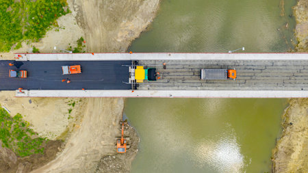 Above top view, overhead, on transportation with truck delivery of hot tarmac over unfinished...
