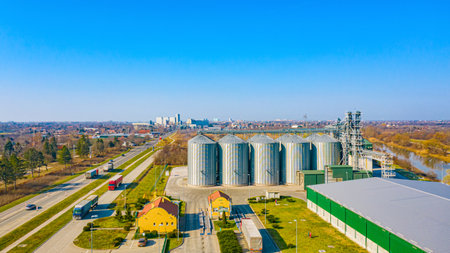 Above view on agricultural industrial zone, complex with few metal silos, storage tanks, warehouse,...