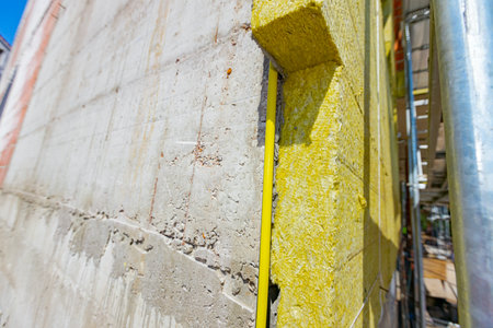 Applying thermal isolation stone wool on the brick wall of residential building under construction. Heat insulation with mineral wool.の写真素材