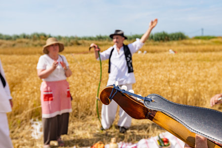 Close up shot on headstock of acoustic guitar, black leather belt is tied on it. Playing music before the start of wheat harvest on traditional rural wayのeditorial素材