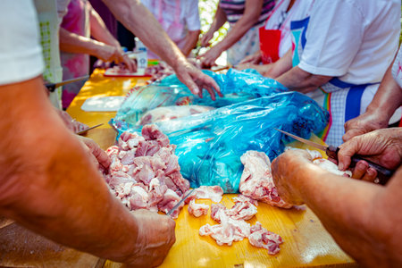 View on seniors, elderly people, pensioners, man and women are standing and cutting fresh raw meat...