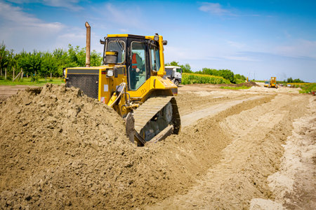 Earthmover with caterpillar is moving earth on the building site.