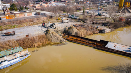 Above top view on workers as they cutting old large vessel, barge, dismantling ship in pieces, cut out rusty metal for scarp, using acetylene torch, recycling, sparks are fly around.の写真素材