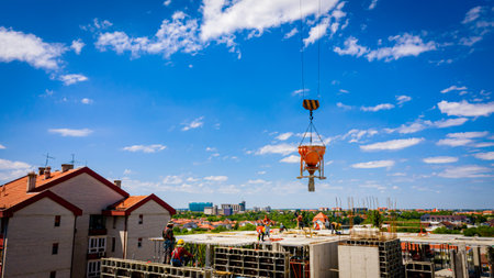 Above view on tower crane as carry cone tank, conical metal bucket to transport and deliver concrete...