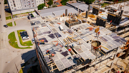 Above view on tower crane as carry cone tank, conical metal bucket to transport and deliver concrete...