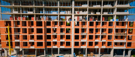 Above view on concrete skeleton of new unfinished large storey building, residential complex under construction, urban site. Exterior of a modern tall apartment buildingの写真素材
