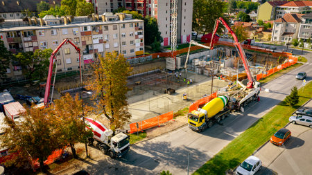 Above view, construction site at cityscape, mixer truck pour concrete in pump machine, pumping to...