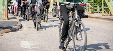 Group of young people cycling, ride bicycles in city, in crowd they try to draw attention to the...