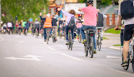 Group of young people cycling, ride bicycles in city, driving in crowd they try to draw attention to the danger for cyclists in traffic, urban environment.の写真素材
