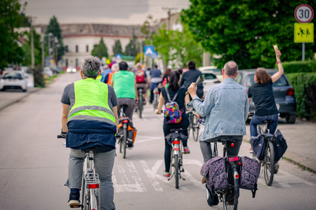 Group of young people cycling, ride bicycles in city, they try to draw attention to the danger for...