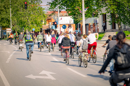 Group of young people cycling, ride bicycles in city, in crowd they try to draw attention to the danger for cyclists in traffic, urban environment.の写真素材