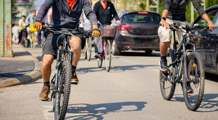 Group of young people cycling, ride bicycles in city, driving in crowd they try to draw attention to the danger for cyclists in traffic, urban environment.の写真素材