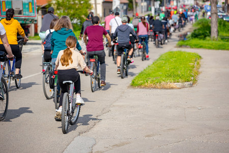 Group of young people cycling, ride bicycles in city, driving in crowd they try to draw attention to the danger for cyclists in traffic, urban environment.の写真素材