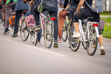 Group of young people cycling, ride bicycles in city, driving in crowd they try to draw attention to...