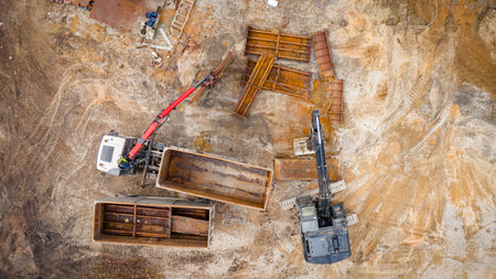 Above view on excavator and tow grapple truck with hydraulic grappling claw, multivalve grab hand, gripper machine, manipulator, loading part of vessel into container, collect rusty metal, recycling.の写真素材