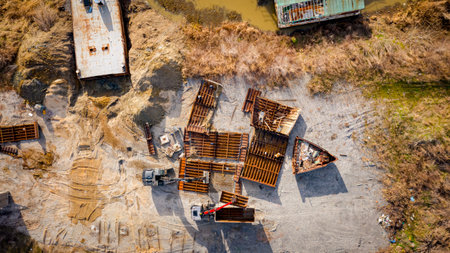 Above view on excavator and tow grapple truck with hydraulic grappling claw, multivalve grab hand, gripper machine, manipulator, loading part of vessel into container, collect rusty metal, recycling.の写真素材