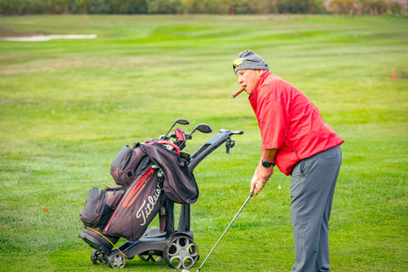 Zabalj, Vojvodina, Serbia - October 04, 2025: People are playing golf, walking over grass field during golfing game, course. They carry bag with equipment or pull cart, trolley.のeditorial素材