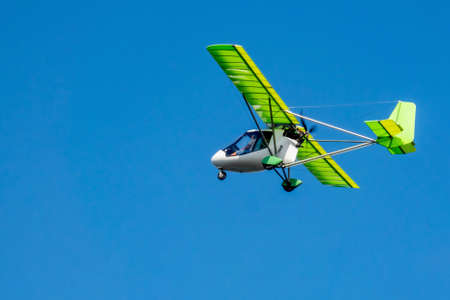 Light two-seat aircraft in the air. Copy space.