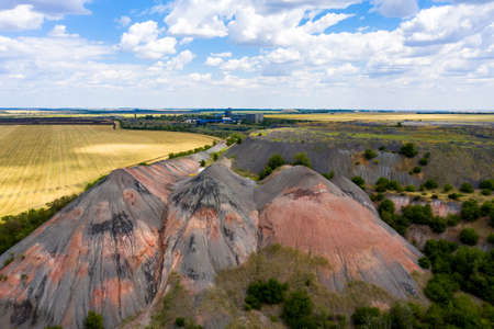 Technogenic terrain with waste rock dumps formed after mining. Shooting from a drone.の写真素材
