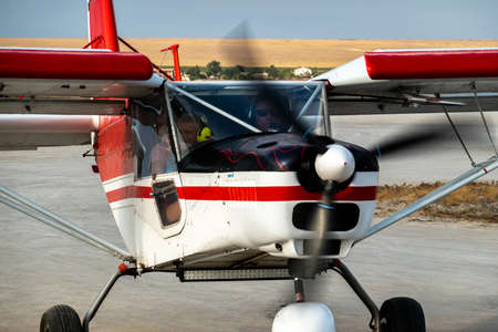 Crimea, Olenevka, August 20, 2020: a fragment of a light two-seat aircraft before takeoff. The plane's propeller rotates.のeditorial素材