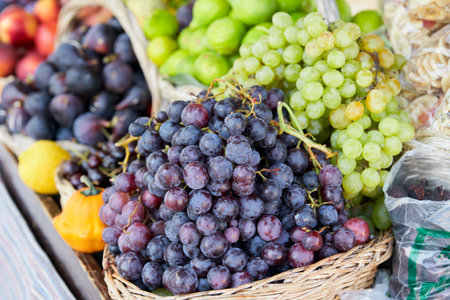 Fruit market. A counter with grapes and figs in wicker baskets. Selective focus.