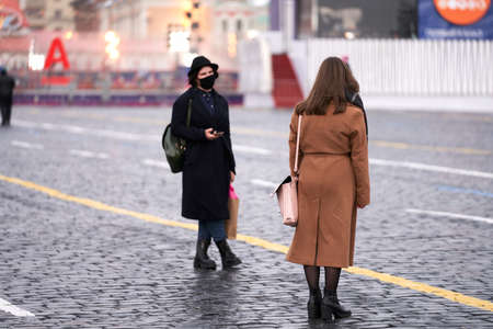 Russia, Moscow, January 25, 2021: two girls in medical masks, one of whom is dressed in a Gothic style, walk through Red Square. Selective focus.のeditorial素材