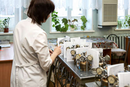 Laboratory of Soil Mechanics. The laboratory assistant takes readings from compression devices....