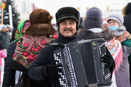 Yelabuga, Russia, March 14, 2021: street harmonica player surrounded by women.のeditorial素材